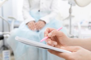 pasien wanita muda saat konsultasi dengan dokter spesialis obgyn di institusi medis